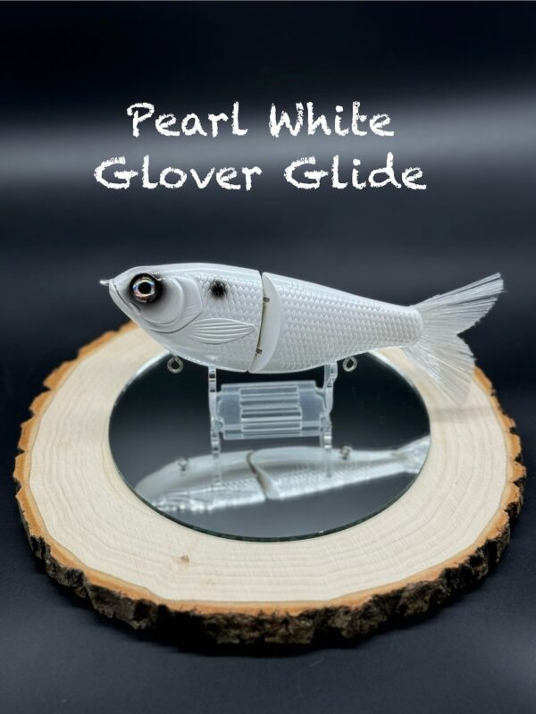 A mostly white fishing lure with black around the eye and a black spot under the title "Pearl White Glover Glide".