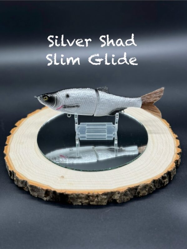 A silver and black fishing lure under the title "Silver Shad Slim Glide".