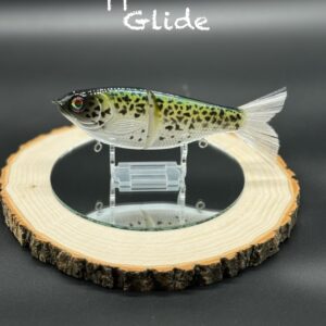 A green and yellow fishing lure with black speckles under the title "Crappie Glover Glide".