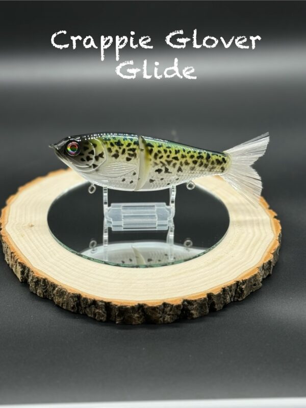 A green and yellow fishing lure with black speckles under the title "Crappie Glover Glide".