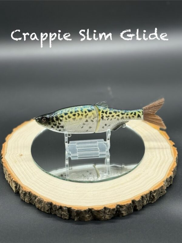 A green and yellow fishing lure with black speckles under the title "Crappie Slim Glide".