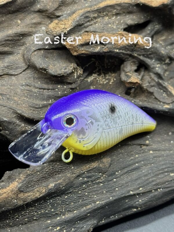 A squarebill lure with a deep purple back, white side, yellow belly, and some silver flecks along the side.