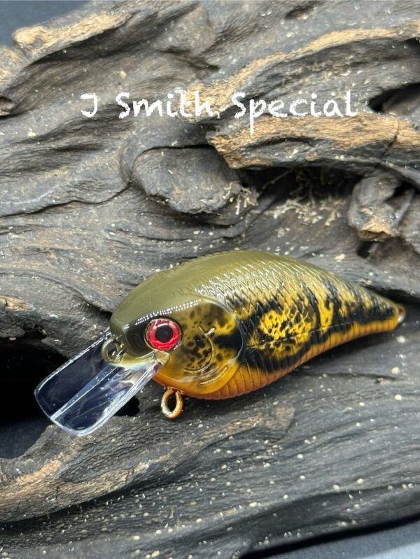 An olive green, yellow, and orange squarebill lure with black detailing under the title "J Smith Special".