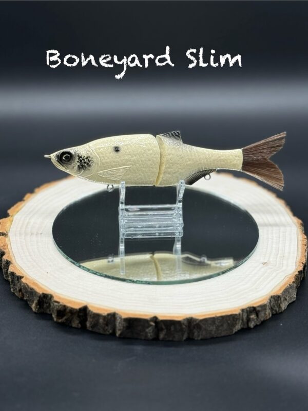 A pale yellow fishing lure with black spots under the title "Boneyard Slim".